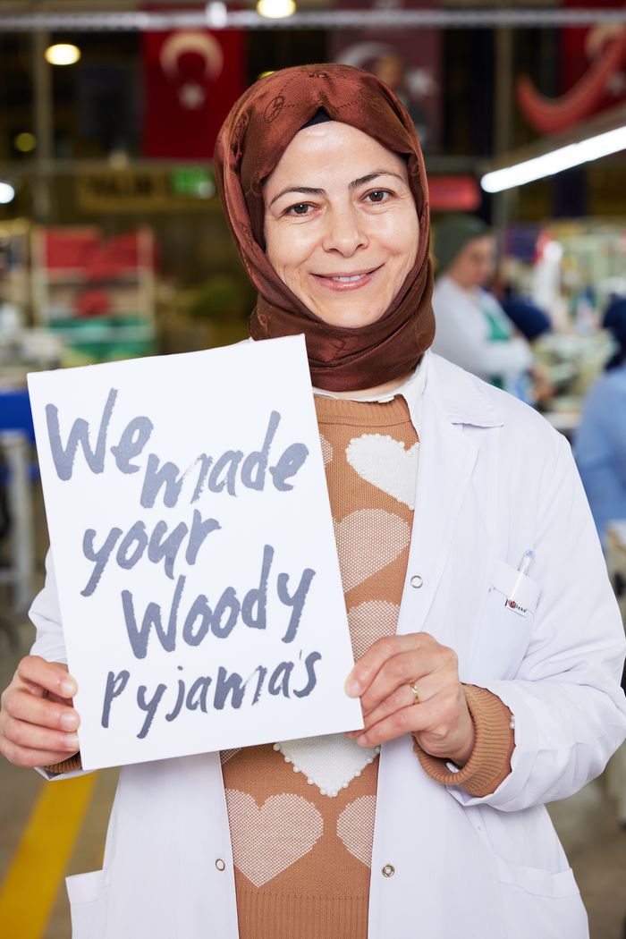 'We made your Woody pyjamas' yazılı kartı tutan çalışan