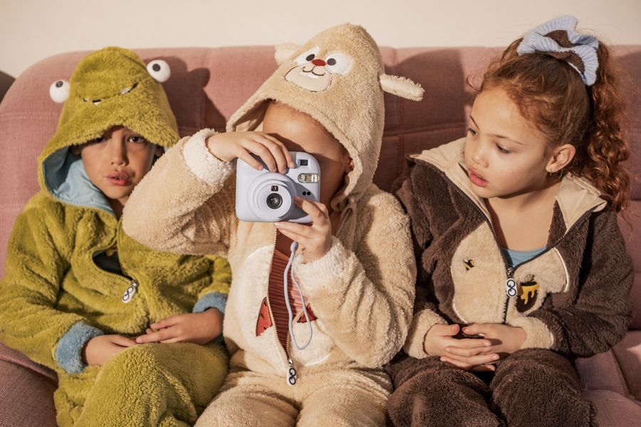 Hayvan kostümlü pijamalarla kanepede çocuklar